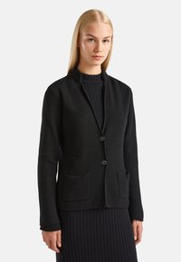 Černý pletený kardigan s texturovaným povrchem, bez límce, se dvěma předními kapsami a jednobodovým zapínáním.