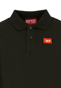 Polo noir avec col, trois boutons, et un patch logo rouge Diesel. Confectionné en coton, il présente une texture lisse et un design minimaliste.