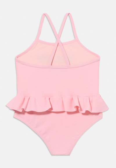 Ροζ ανοιχτού χρώματος παιδικό μαγιό με βολάν στη μέση και λεπτές, σταυρωτές τιράντες σε μονόχρωμο φόντο.