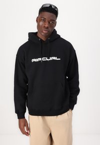 Hanorac cu glugă negru, cu logo alb, buzunar tip cangur și manșete cu nervuri. Material moale, croi lejer, design simplu.