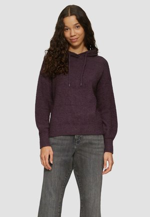 Paarse, zacht-textuur hoodie met een voorzak en verstelbare trekkoorden. Gecoördineerd met grijze denim jeans.