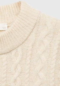 Maglione a lavorazione cable-knit di colore crema con scollo rotondo a coste. Texture morbida e motivi intrecciati in evidenza. Etichetta del tessuto visibile all'interno del colletto.