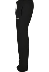 Sorte tapered sweatpants med sidelommer, snøre i livet og diskret tekstdetalje på låret. Fremstillet af blødt, let vævning.