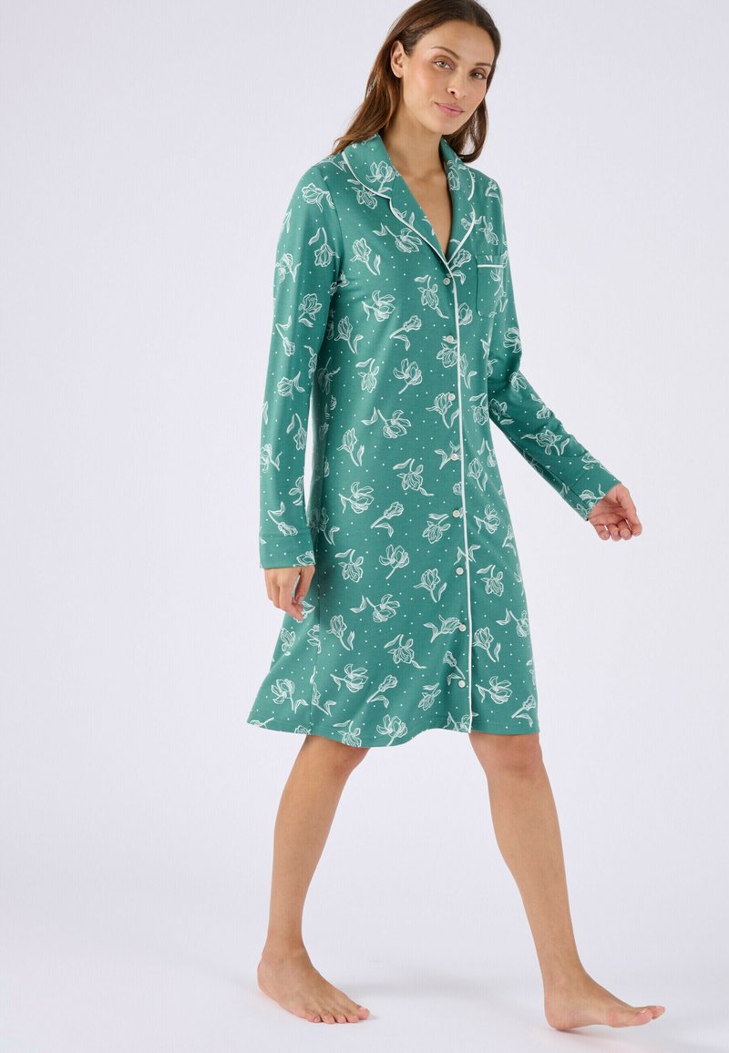 Nuisette en coton verte à motif floral, manches longues et boutonnage frontal, avec un biais blanc contrastant le long du col.