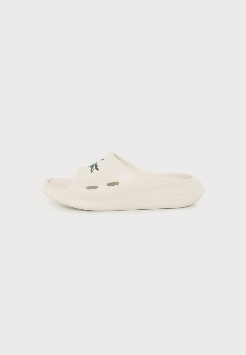 Λευκό σανδάλι slip-on με οπές αερισμού και λογότυπο Lacoste στο επάνω μέρος, σχεδιασμένο για casual χρήση και άνεση.