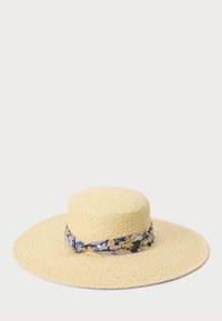 Bredkantet stråhatt i lys gul, med et blomstermønster i blått, beige og krem rundt kransen. Strukturert vevd design.
