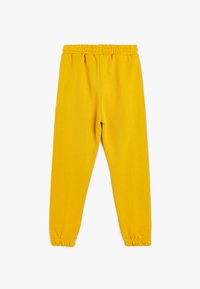 Gelbe Sweatpants mit einem elastischen Bund, schmal zulaufenden Bündchen und einer glatten Textur, in einer einfarbigen Ausführung ohne Muster oder Akzente.