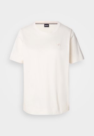 Balts kokvilnas T-krekls ar īsām piedurknēm, apaļu kakla izgriezumu un mazu logo uz krūtīm. Gluda tekstūra un taisna apakšmala.