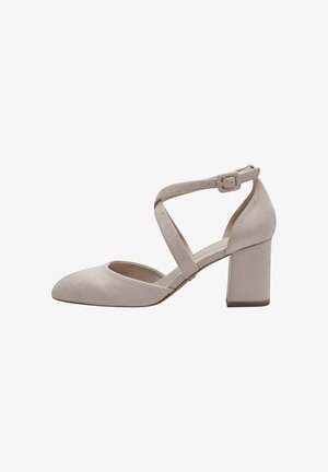 Beige nubuck pump met een spitse neus en een brede blokhak. Voorzien van een kruisband met een gespsluiting voor een veilige pasvorm. Gladde textuur.