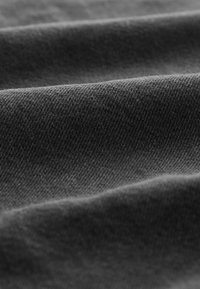 Tejido gris con un tejido texturizado, que muestra una superficie suave y lisa con pliegues sutiles y un color uniforme.