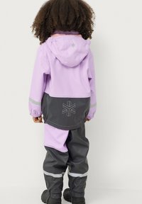 Waterdichte twee-delige set met een lila jas met capuchon en elastische manchetten, gecombineerd met grijze broek, reflecterende accenten en een logodetail.