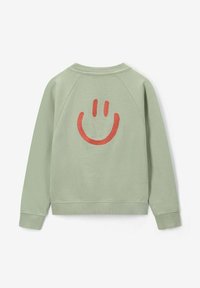 Sweatshirt vert au toucher doux, avec un grand smiley rouge brodé dans le dos et des poignets et un col côtelés.