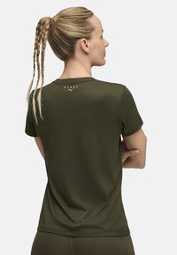 Alyvinės žalios spalvos sportinė marškiniai, trumpomis rankovėmis, lygaus tekstūros, su "HYROX" logotipu ant nugaros, derinama su prigludusių kelnių.