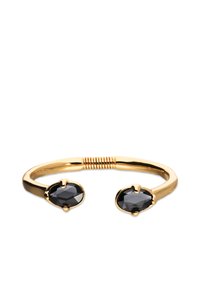 Brazalete de tono dorado con dos piedras preciosas negras ovaladas, acabado liso y una sección central retorcida para mayor flexibilidad.