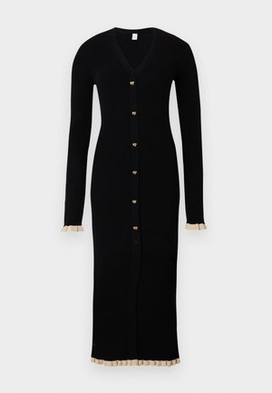 Robe longue noire en tricot côtelé avec un décolleté en V, boutons dorés en forme de cœur sur le devant, et accents en beige à volants aux poignets et à l'ourlet.