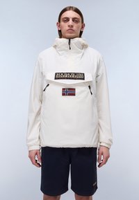 Biała, lekka kurtka typu pullover z zapinana na zamek kieszenią z przodu, logo z czarnym tekstem oraz małą naszywką flagi Norwegii na piersi.