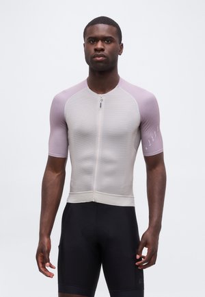 Mand iført en tætsiddende cykeltrøje med korte ærmer med lysegrå front og lavendelærmer kombineret med sorte cykelshorts.