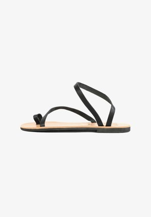 Sandalias de cuero negro con múltiples tiras finas, suela plana y plantilla de color natural. Diseño simple y minimalista sin adornos.