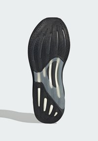 Suola di scarpa da ginnastica nera con gomma texture, caratterizzata da sezioni traslucide e accenti bianchi, progettata per una maggiore aderenza e flessibilità.