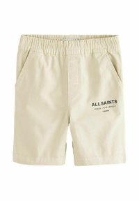 Beige shorts med elastisk midjeband, två sidfickor och en tryckt logotyp längst ner till höger. Slät bomullstyg, avslappnad design.