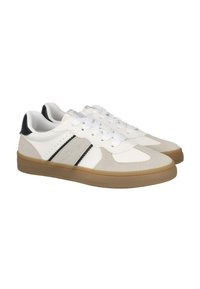 Zapatillas blancas y beige con texturas de ante y cuero, detalles en negro, diseño de cordones y suela de goma. Presenta costuras laterales.