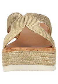 Zlaté pruhované sandály se korkovou podrážkou, s robustní platformou a texturovaným svrškem. Barva a materiál vytvářejí přirozený vzhled.