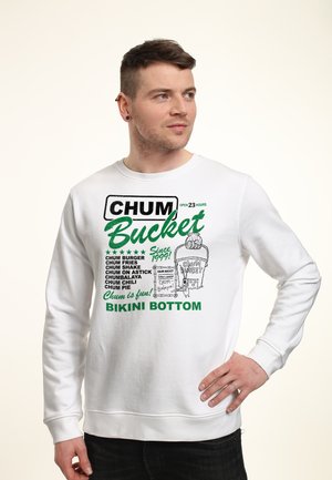 Man wearing white sweatshirt with green and black "Chum Bucket Bikini Bottom" text and cartoon bucket graphic on front.