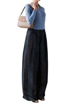 Haut à manches longues bleu clair avec boutons, associé à un pantalon taille haute, plissé, à jambes larges en denim foncé. Petit sac à main avec détails texturés.