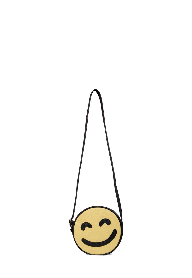 Borsa crossbody rotonda gialla con un design di faccina sorridente, accenti neri e superficie testurizzata. Tracolla nera regolabile per il trasporto.