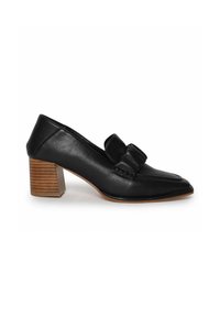 Zapato de tacón de cuero negro con punta afilada y un lazo decorativo en el empeine. Tacón de bloque de madera, textura suave y sutiles detalles de costura.