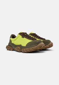 Zapatos de senderismo en verde lima y marrón con suelas texturizadas, que cuentan con cordones oscuros y un collarín acolchado. Adecuados para actividades al aire libre.