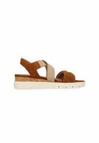 Braune Wildledersandalen mit Kreuzriemen, elastischen Details, Kork-Blockabsatz und einer weißen Gummisohle mit strukturiertem Finish und Belüftungslöchern.