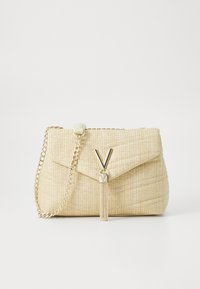 Audinė smėlio spalvos rankinė su tekstūruotu paviršiumi, auksinės grandinėlės petneša ir V formos metaliniu uždarymu su kutu akcentu.