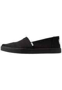 Svarta slip-on skor med en strukturerad kanvas ovandel, rund tå och gummisula. Har en liten varumärkesetikett och blå accent på hälen.