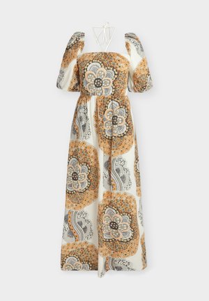 Femme portant une robe longue crème avec des motifs floraux orange et gris, manches bouffantes, tenant un sac à main en cuir noir avec des poignées rondes.