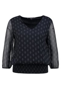 Svart topp med långärmar i genomskinligt material, v-ringning och elastisk fåll. Har ett strukturerat mönster av små diamantformer i silver.