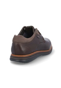Zapato de cuero marrón con una textura suave, punta redondeada y una entresuela en tono marrón claro que contrasta. Presenta cordones marrones y un forro de tela, mostrado desde la parte trasera.