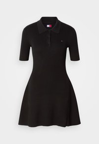Robe polo noire à manches courtes côtelée avec col, patte de boutonnage à trois boutons et petit logo Tommy Jeans sur la poitrine.