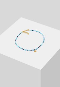 Kleurrijke kralenketting met blauwe, zwarte en gouden kralen, versierd met een klein gouden schelpencharme. Verstelbare gouden sluiting voor maatvoering.