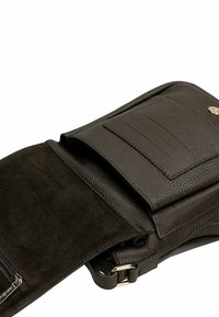 Borsa in pelle marrone con esterno testurizzato, chiusura a pattina, slot per carte interne e tasca con zipper. Finiture lisce e scamosciate.
