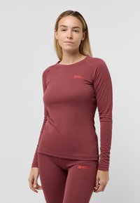 Bordeaux kleurige lange mouwen sportshirt gemaakt van gladde, rekbare stof; heeft een logo op de borst en een figuur-hugging ontwerp voor actieve kleding.