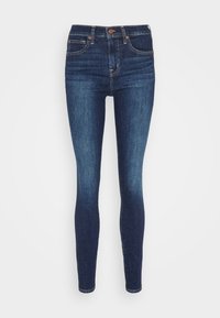 Sötét kék farmerből készült skinny nadrág. Magas derekú, sima textúrájú, hagyományos öt zsebes kialakítással és narancs öltés részletekkel.