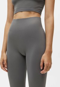 Grijze geribbelde legging met een hoge tailleband, voorzien van een gladde textuur. Het aansluitende ontwerp volgt de contouren van het lichaam.