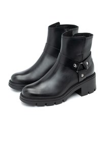 Czarne skórzane botki z gładką powierzchnią, okrągłym noskiem, grubą podeszwą oraz regulowanym paskiem z ozdobnym okuciem po boku.