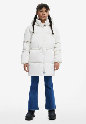 Weißer Pufferjacke mit hohem Kragen und Kapuze, ausgestattet mit einem Reißverschluss, elastischem Gummizug in der Taille und großen gepolsterten Bereichen. Trägt dazu blaue Schlagjeans.