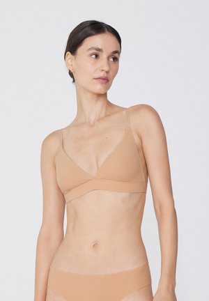 Bralette triangolo nudo in morbido tessuto con spalline regolabili. Design senza cuciture con una texture liscia e uno stile minimalista.