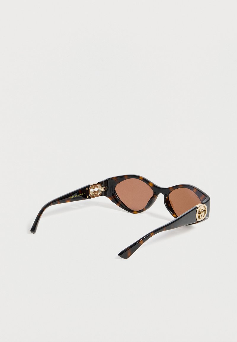 Schildpatt-Katzenaugen-Sonnenbrille mit braunen Gläsern und goldenen Doppel-G-Logo-Akzenten an schwarzen Bügeln.
