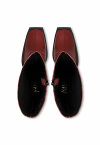 Piros bőr bokacsizma négyzet alakú orral, fekete belső béléssel és cipzáras kiegészítőkkel mindkét oldalon. Simára csiszolt felület, alacsony sarokkal.