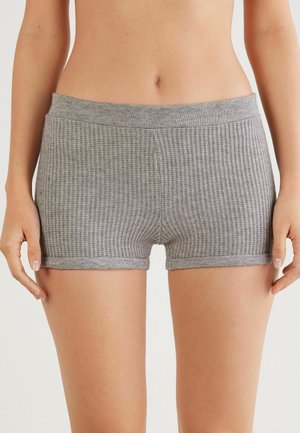 Shorts en tricot gris côtelés avec une taille élastique. Longueur courte et design ajusté. Détails de couture visibles le long des bords.