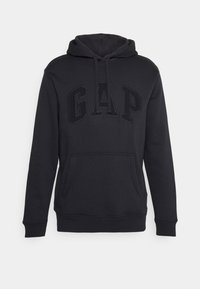 Sudadera negra hecha de una mezcla de algodón, con un bolsillo frontal tipo canguro, capucha con cordones y un logo en relieve de "GAP" en un color a juego.